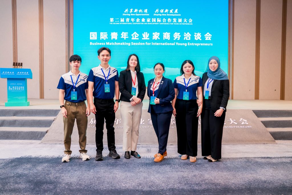 YEAB members standing alongside a PRISM banner at a local business community event in Brunei